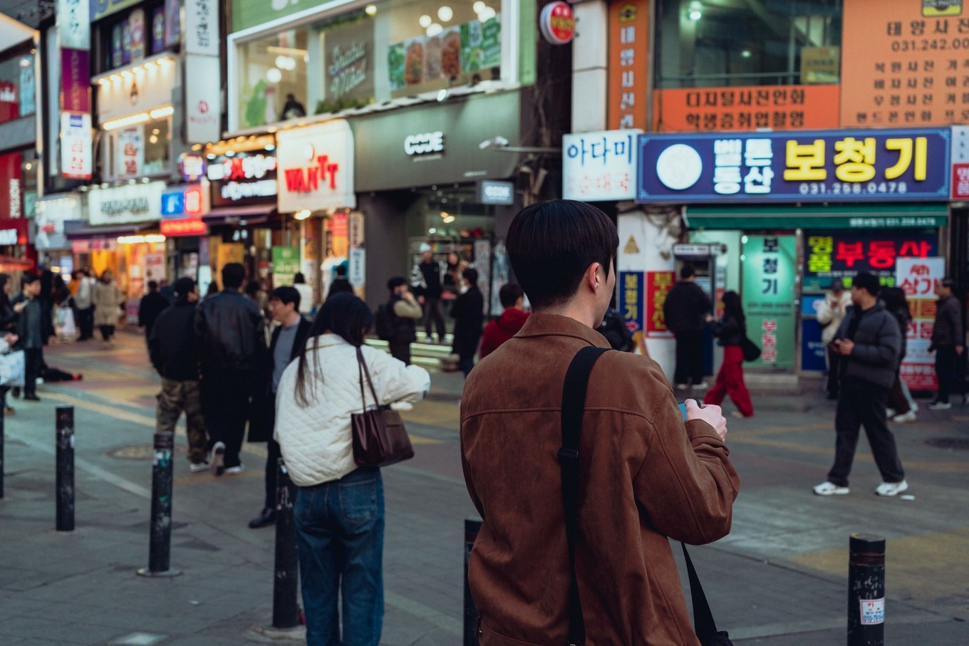 수원 거리를 찍은 사진. 한글 간판과 전화번호, 사람들, 보도블록이 한 화면에 들어 있다